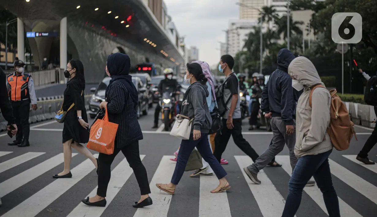 Pekerja kantoran menyebrang menggunakan fasilitas Pelican Crossing di kawasan Jalan Thamrin, Jakarta, Kamis (5/1/2023). Pencabutan Pemberlakuan Pembatasan Kegiatan Masyarakat (PPKM) dinilai untuk menggenjot ekonomi Indonesia 2023 yang diproyeksi suram akibat resesi global. (Liputan6.com/Faizal Fanani)