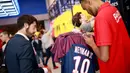 Fans memilih jersey pemain baru Paris Saint Germain, Neymar Jr, di toko merchandise di Paris, Jumat (4/8/2017). Setelah resmi bergabung dengan Paris Saint Germain, jersey Neymar Jr langsung diburu suporter klub Ibu kota. (AFP/Benjamin Cremel)