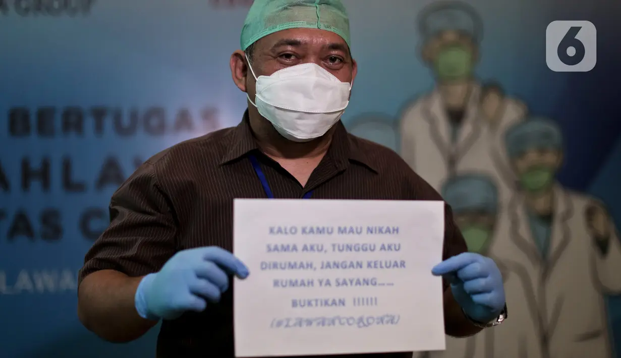 Dokter dan tenaga medis membawa tulisan berisi pesan dan tulisan untuk melawan virus corona saat sesi foto di posko tenaga medis Covid-19, Jakarta, Kamis (2/4/2020). Aksi ini mengharapkan masyarakat berdiam diri di rumah, untuk ikut bergerak memutus mata rantai covid-19. (Liputan6.com/Johan Tallo)