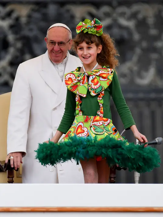 Paus Francis menyaksikan atraksi seorang anak dari tim Sirkus Rony Roller saat memimpin acara mingguan di Saint Petrus di Vatikan, Rabu (22/2). (AFP Photo / Alberto Pizzoli)