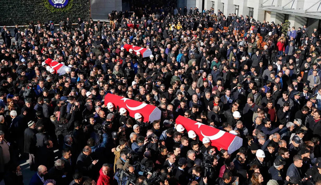 Petugas membawa peti mati saat upacara pemakaman anggota Polisi yang tewas dalam ledakan bom di Istanbul, Turki (11/12). Sedikitnya 27 polisi yang menjadi korban, di antaranya adalah seorang kepala polisi dan perwira senior lainnya. (Reuters/Murad Sezer)