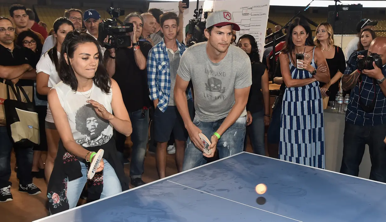 Pasangan selebriti, Mila Kunis (kiri) dan Ashton Kutcher (kanan) saat bermain pingpong di acara tahunan ke-6 dari Clayton Kershaw, Ping Pong 4 Purpose, Los Angeles, Amerika Serikat, Kamis (23/8). (CHRISTOPHER POLK/GETTY IMAGES NORTH AMERICA/AFP)