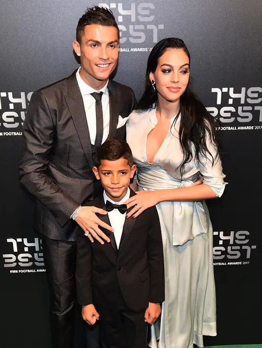 Bintang Real Madrid, Cristiano Ronaldo bersama pasangannya, Georgina Rodriguez dan sang putra, Cristiano Ronaldo Jr berpose setibanya di karpet hijau acara The Best FIFA Football Awards, London, Senin (23/10). (Glyn KIRK/AFP)