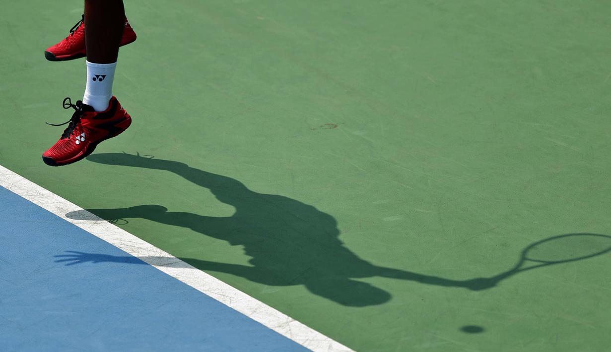 Siluet dari petenis Indonesia, M. Rifqy Fitriadi, saat berusaha mengembalikan bola saat melawan petenis Selandia Baru, Ajeet Rai, pada laga Piala Davis 2019 Grup II Zona Asia/Oceania di Stadion Tenis GBK, Jakarta, Sabtu (14/9). Rifqi kalah 6-7, 3-6 dari Ajeet. (Bola.com/Peksi Cahyo)