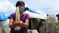 Seorang anak penyintas gempa Palu yang masih tinggal di tenda darurat Balaroa, Palu, menunjukkan Hand Sanitizer yang didapatnya secara gratis, Kamis (26/3/2020). (Foto: Liputan6.com/ Heri Susanto).