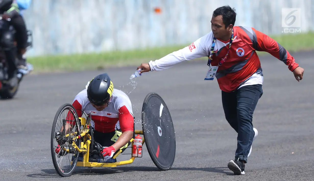 Atlet ParaCycling, Soemantri diguyur tubuhnya saat laga di nomor Mens H4-5 Road Race Asian Para Games 2018 di Sirkuit Sentul, Bogor, Selasa (9/10). Soemantri berhasil merebut medali perunggu. (Liputan6.com/Helmi Fithriansyah)