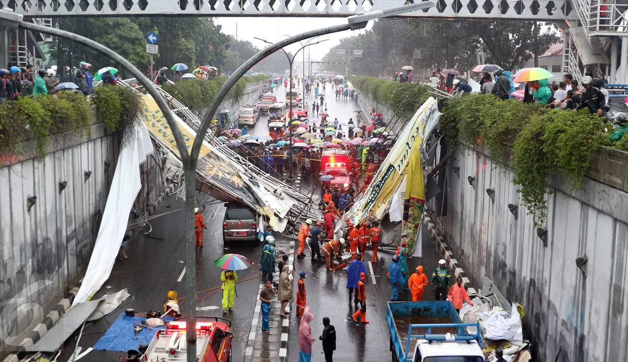 Petugas berusaha memotong bagian JPO yang roboh di Jalan Raya Pasar Minggu, Jakarta Selatan, Sabtu (24/09). Tiga unit mobil tertimpa akibat JPO yang jarang dipergunakan lagi. (Liputan6.com/Immanuel Antonius)