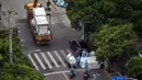Pekerja yang mengenakan alat pelindung diri berdiri dekat kotak yang akan dikirim saat perberlakuan lockdown karena virus corona COVID-19 di Distrik Jing'an, Shanghai, China, Rabu (18/5/2022). (Hector RETAMAL/AFP)