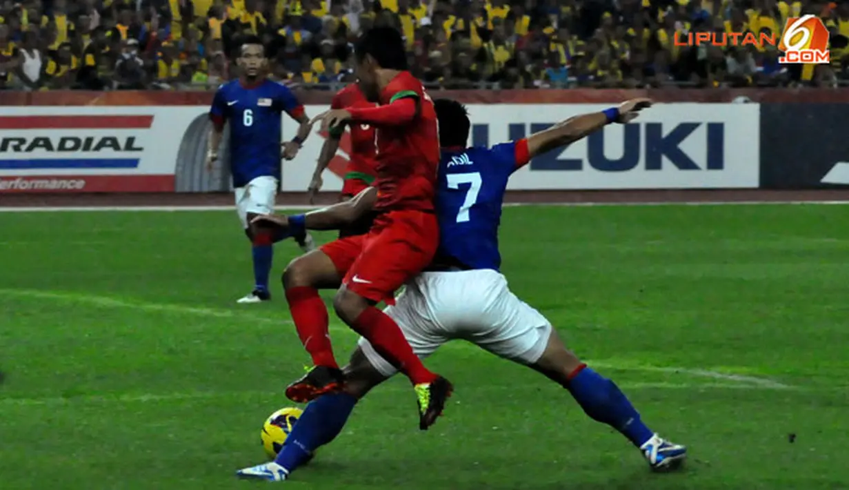 Duel Pemain Indonesia dengan Pemain Malaysia dalam Laga Piala AFF Suzuki 2012 antara Malaysia vs Indonesia di Stadion Bukit Jalil, Kuala Lumpur, Malaysia. pertandingan berakhir dengan skor 2-0 untuk Malaysia.