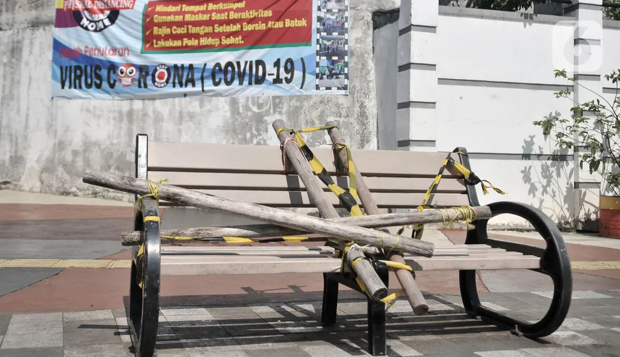 Kondisi bangku trotoar yang disegel garis pembatas dan ditutupi bambu di kawasan Rawamangun  Jakarta, Minggu (3/5/2020). Bangku trotoar di sepanjang jalan Rawamangun disegel untuk mencegah kerumunan warga sebagai upaya memutus rantai penyebaran COVID-19. (merdeka.com/Iqbal S. Nugroho)