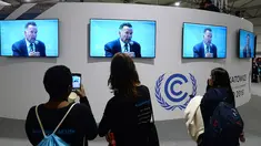 Pengunjung menonton pidato Arnold Schwarzenegger di Katowice, Polandia (3/12). Arnold Schwarzenegger membahas status dan pengendalian perubahan iklim global saat menjadi pembicara di forum tertinggi tersebut. (AP Photo/Czarek Sokolowski)