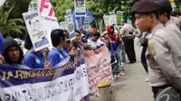 Petugas Polisi bersiaga saat buruh migran menggelar aksi di Istana Negara, Jakarta, Kamis (18/12/2014). (Liputan6.com/Faizal Fanani)