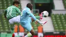 Pemain Werder Bremen, Theodor Gebre Selassie, berebut bola dengan pemain Wolfsburg, Jerome Roussillon, pada laga Bundesliga di Weserstadion Minggu (7/6/2020). Werder Bremen takluk 0-1 dari Wolfsburg. (AFP/Patrik Stollarz)