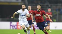 Gelandang Rapid Wien, Andrei Ivan melewati Marcelo Brozovic pada leg 2, babak 16 besar Liga Europa yang berlangsung di stadion Giuseppe Meazza, Milan, Jumat (22/2). Inter Milan menang 4-0 atas rapid Wien. (AFP/Miguel Medina)
