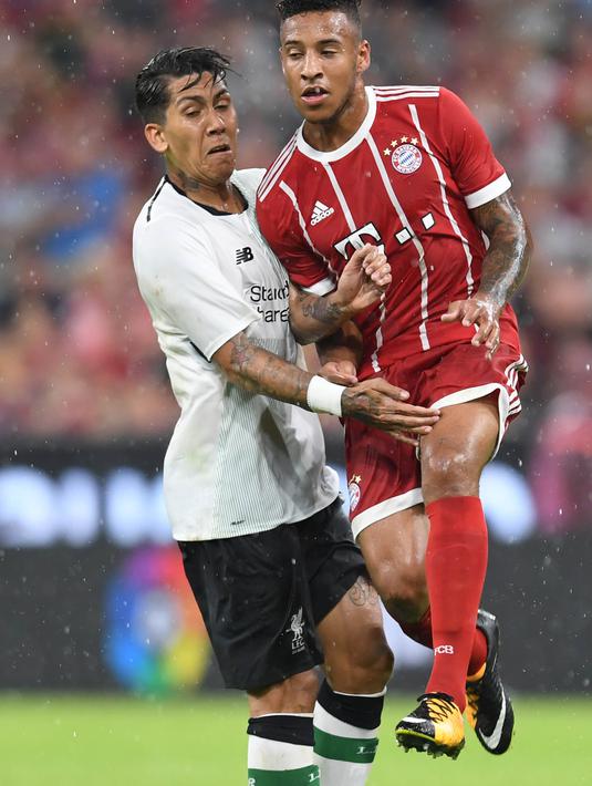 Striker Liverpool, Roberto Firmino, menahan laju gelandang Bayern Munchen, Corentin Tolisso, pada laga Audi Cup di Stadion Allianz Arena, Munchen, Selasa (1/8/2017). Munchen kalah 0-3 dari Liverpool. (AFP/Christof Stache)