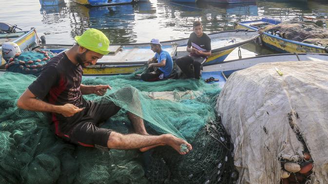 Para nelayan bekerja di sebuah pelabuhan Gaza City, 13 Agustus 2020. Otoritas Israel pada 12 Agustus 2020 waktu setempat mengumumkan larangan pengiriman bahan bakar ke Gaza dan mempersempit zona penangkapan ikan nelayan Gaza dari 15 menjadi delapan mil laut. (Xinhua/Rizek Abdeljawad)