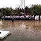 Upacara memperingati HUT PGRI dan Hari Guru Nasional di bawah guyuran hujan. Foto: (Jayadi Supriadin/Liputan6.com)