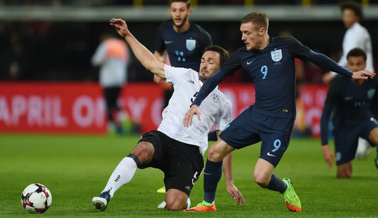 Bek Jerman, Mats Hummels, berusaha menghalau striker Inggris, Jamie Vardy. Dalam pertandingan tersebut Inggris menguasai pertandingan dengan penguasaan bola hingga 51 persen sedangkan Jerman 49 persen. (AFP/ Patrik Stollarz)