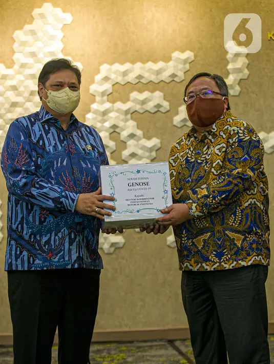Menristek Bambang Brodjonegoro (kanan) memberikan GeNose C19 kepada Menko Bidang Perekonomian Airlangga Hartarto di Gedung Kemenko Perekonomian, Jakarta, Senin (22/3/2021). GeNose C19 diharapkan dapat semakin dikenal dan dimanfaatkan secara lebih masif. (Liputan6.com/Faizal Fanani)