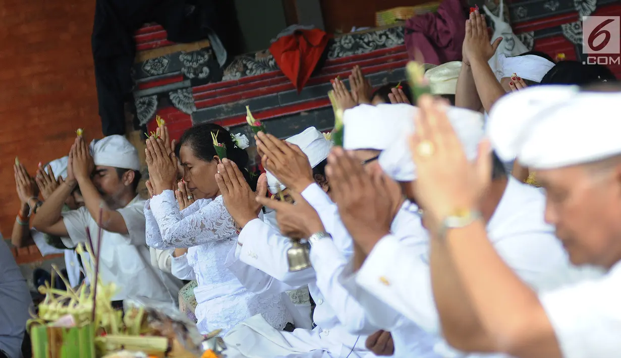 Umat Hindu bersembahyang selama prosesi upacara mecaru di Pura Tribhuana Agung Sukmajaya Depok, Jawa Barat, Rabu (6/3). Upacara Mecaru dilaksanakan bertujuan untuk menjaga keharmonisan antara manusia dan alam. (Liputan6.com/Herman Zakharia)