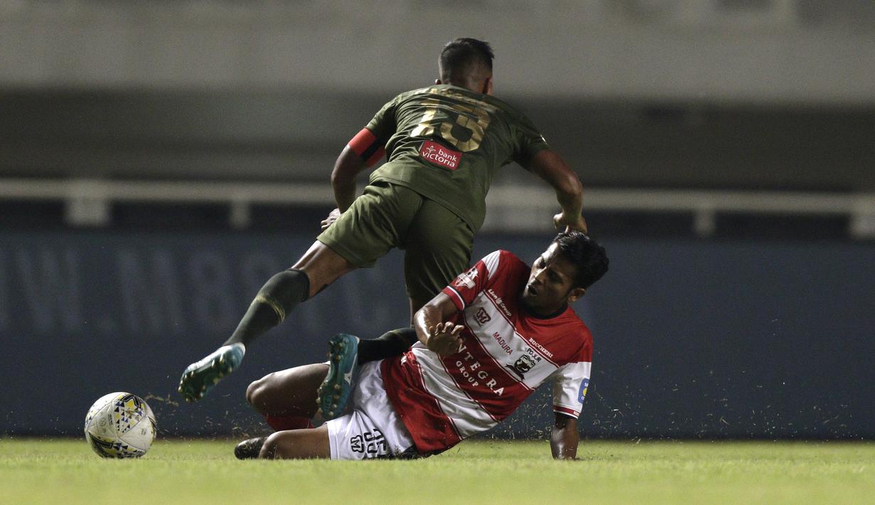 Gelandang Madura United, Zulfiandi, merebut bola dari pemain Tira Persikabo pada laga Shopee Liga 1 di Stadion Pakansari, Bogor (12/7). Tira bermain imbang 2-2 atas Madura. (Bola.com/Yoppy Renato)