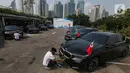 Petugas membersihkan mobil BMW i7 dan i5 di komplek GBK, Senayan, Jakarta, Jumat (3/5/2024). (Liputan6.com/Angga Yuniar)
