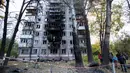 Penduduk setempat berjalan di sekitar gedung bertingkat mereka yang rusak akibat ledakan serangan pesawat tak berawak di Kyiv, pada 30 Oktober 2024. (Anatolii STEPANOV/AFP)