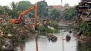 Sebuah eskavator terus melakukan upaya perataan Kampung Pulo, Jakarta, Jumat (21/8/2015). Penggusuran terkait rencana Pemprov DKI Jakarta yang akan melakukan normalisasi Kali Ciliwung. (Liputan6.com/Helmi Fithriansyah)