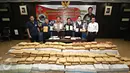 Petugas menunjukkan barang bukti dan tersangka saat rilis pengungkapan jaringan Narkotika sindikat Aceh-Jakarta-Bali di Jakarta, Senin (28/12/2015). Bareskrim amankan 3 kg sabu, 14.000 butir ekstasi, dan 1,5 ton ganja. (Liputan6.com/Immanuel Antonius) 