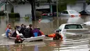 Tim SAR mengevakuasi warga menggunakan perahu karet melintasi banjir di San Jose, California, Selasa (21/2). Banjir terjadi akibat meluapnya Sungai Coyote Creek yang tidak mampu menampung debit air setelah hujan lebat. (AP Photo/Marcio Jose Sanchez)