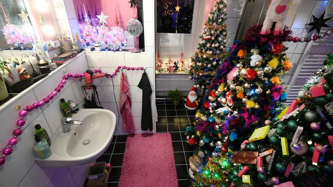 Pohon-pohon Natal yang sudah didekorasi memenuhi kamar mandi di rumah keluarga Thomas Jeromin di Rinteln, Jerman, 8 Desember 2019.  Thomas Jeromin memenuhi rumahnya dengan 350 pohon Natal di hampir tiap sudut rumah, mulai dari ruang tamu, dapur sampai kamar mandi. (Ina FASSBENDER/AFP)