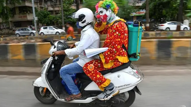 Dengan bantuan alat peraga dan poster, pria India ini dengan sabar menunjukkan kepada mereka cara mencuci tangan dan memakai masker dengan benar (AFP)