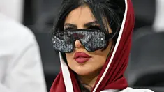 Seorang wanita pendukung Qatar mengenakan kaca mata hitam menghadiri pertandingan Grup A Piala Dunia Qatar 2022 antara Qatar dan Ekuador di Stadion Al-Bayt di Al Khor, utara Doha pada 20 November 2022. (AFP/Glyn Kirk)