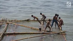 Anak-anak bermain di batang kayu bekas dermaga sandar kapal tradisional di Kawasan Cilincing, Jakarta, Selasa (10/4). Kegiatan bermain air laut ini merupakan bagian dari keseharian mereka sepeluang sekolah. (Merdeka.com/Imam Buhori)