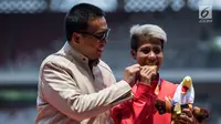 Atlet lompat jauh Indonesia, Rica Oktavia (kanan) foto bersama Menpora Imam Nahrawi usai meraih medali emas Asian Para Games 2018 di SUGBK, Jakarta, Senin (8/10). Rica menorehkan lompatan mencapai 5,25 meter. (Bola.com/Vitalis Yogi Trisna)