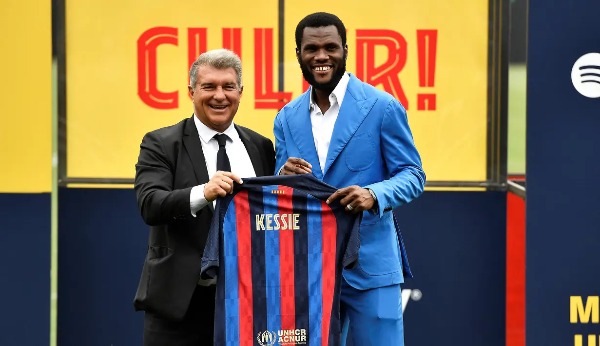 Gelandang baru Barcelona, Franck Kessie berfoto dengan Presiden Barcelona, Joan Laporta sambal memegang jersey barunya selama upacara presentasi di tempat latihan Joan Gamper di Sant Joan Despi, dekat Barcelona (6/7/2022). Pemain asal Pantai Gading ini merapat ke Camp Nou dengan status free transfer. (AFP/Pau Barrrena)