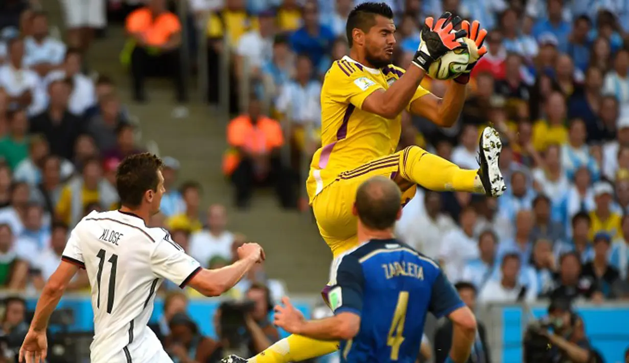 Sergio Romero menangkap bola di udara saat final World Cup 2014 antara Jerman vs Argentina di Stadion Maracana, Rio de Janeiro pada 13 Juli 2014.  (AFP Photo/Odd Andersen)