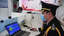 Petugas memeriksa foto yang dikirim oleh mobil pengiriman tanpa awak di Institut Teknologi Beijing, Beijing, China, Senin (6/4/2020). Institut Teknologi Beijing menggunakan mobil pengiriman tanpa awak berteknologi 5G yang dapat mengukur suhu tubuh orang-orang yang memasuki kampus. (Xinhua/Ren Chao)
