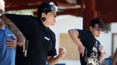 Anggota Pink Pistols bersiap menembak saat mengikuti kelas pelatihan tembak di PMAA Gun Range, Salt Lake City, Utah, AS (13/7). Pink Pistols adalah organisasi pro-senjata nasional LGBT di AS. (REUTERS/Jim Urquhart)