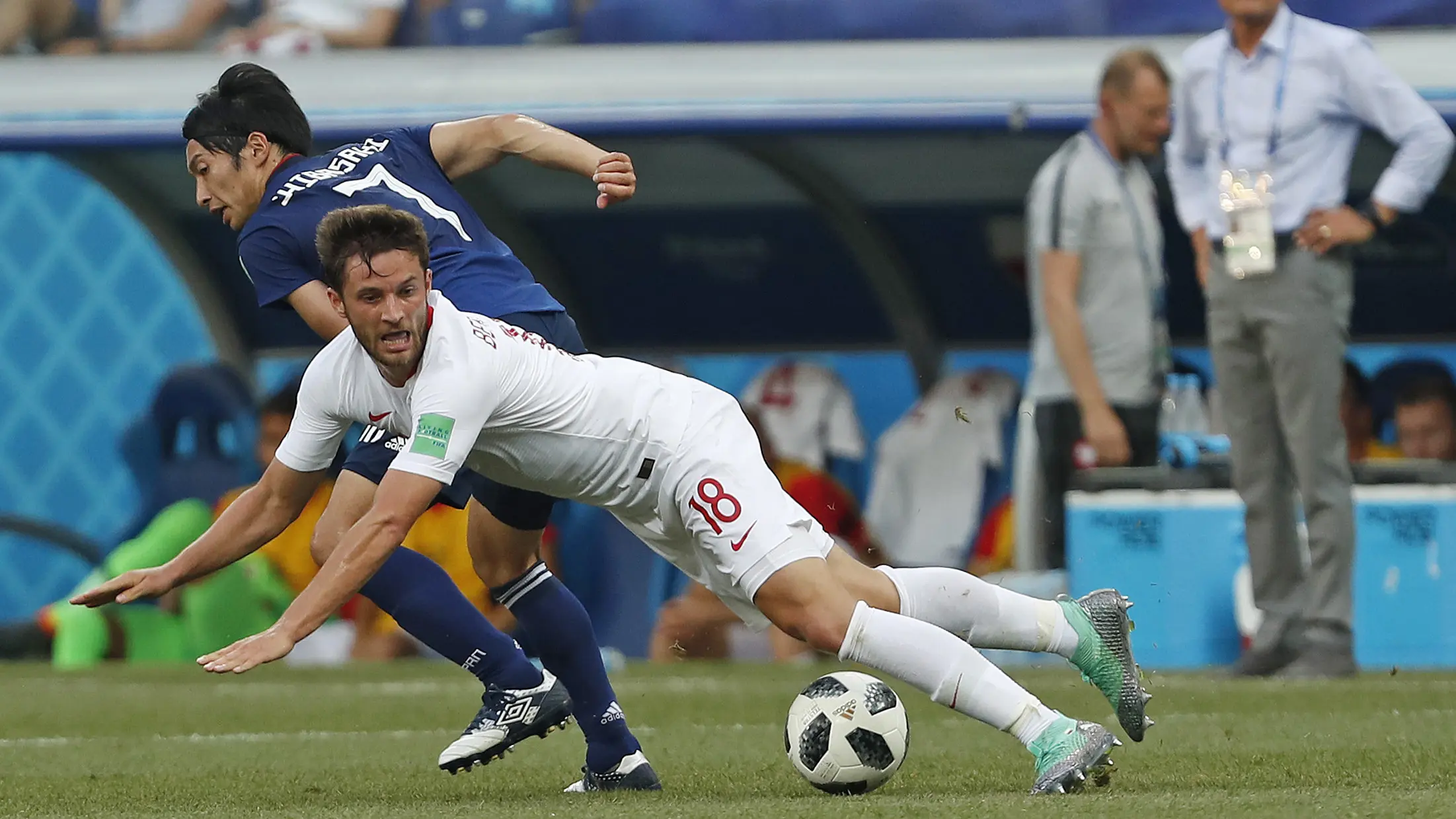 Pemain Polandia, Bartosz Bereszynski (depan) jatuh saat berebut bola dengan pemain Jepang, Gaku Shibasaki pada laga terakhir grup H di Volgograd Arena, Volgograd, Rusia (28/6/2018). Jepang kalah 0-1 dari Polandia. (AP/Darko Vojinovic)