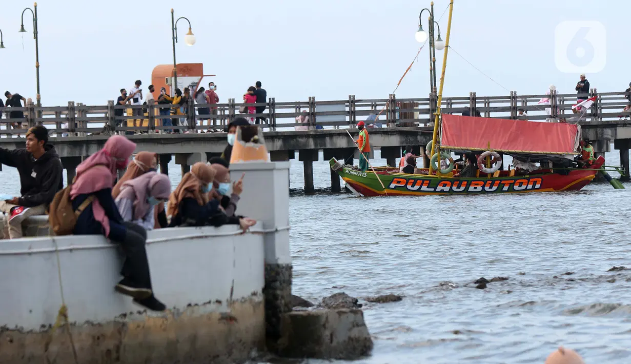Pengunjung menikmati suasana Pantai Indah Taman Impian Jaya Ancol dengan menumpang perahu wisata, Jakarta, Kamis (29/10/2020). Libur panjang di masa pemberlakuan PSBB transisi Jakarta dimanfaatkan warga untuk mengunjungi lokasi-lokasi wiisata. (Liputan6.com/Helmi Fithriansyah)