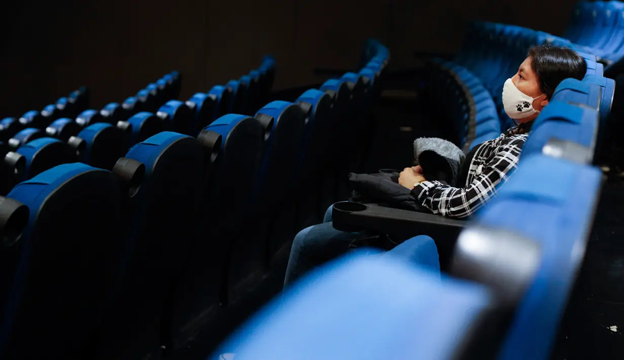 Seorang penonton menunggu dimulainya sebuah film di teater dengan hanya segelintir orang, di bioskop Cineteca Nacional di Mexico City, Rabu (12/8/2020). Setelah ditutup hampir lima bulan akibat Corona, bioskop di ibu kota Meksiko dibuka kembali dengan kapasitas 30%. (AP Photo/Rebecca Blackwell)