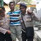 Polisi menggendong pemilih disabilitas ke TPS. (Liputan6.com/Ola Keda)