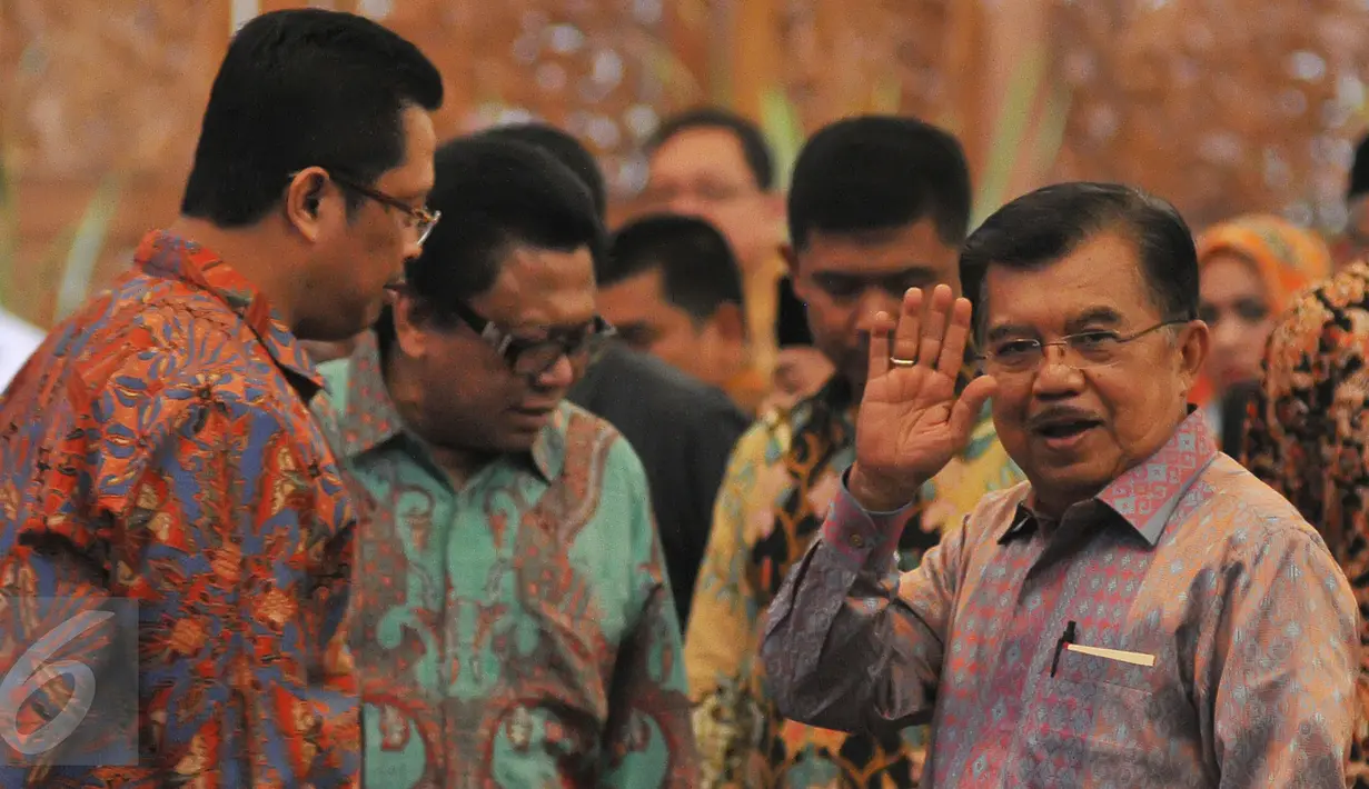 Wapres Jusuf Kalla (kanan)melambaikan tangan kepada awak media saat menghadiri peringatan Hari Konstitusi di Kompleks Parlemen, Senayan, Jakarta, Selasa (18/8/2015). (Liputan6.com/Herman Zakharia)
