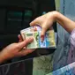 Warga menukarkan uang tunai baru di layanan kas keliling Bank Indonesia di Pasar Kopro, Jakarta Barat, Rabu (29/3/2023). (Liputan6.com/Angga Yuniar)
