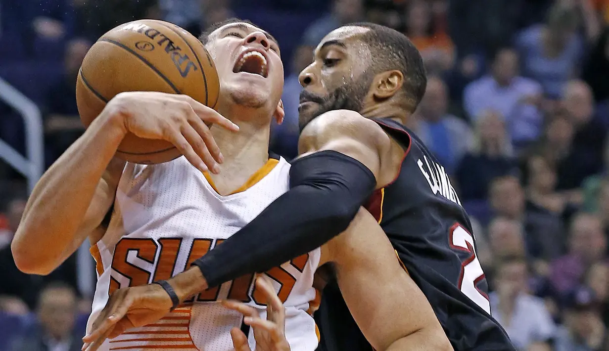 Pemain Phoenix Suns, Devin Booker (kiri) saat berebut bola dengan pemain Miami Heat, Wayne Ellington pada laga NBA basketball game, (3/1/2017) di US Airways Center, Phoenix.  Suns menang 99-90. (AP/Ross D. Franklin)