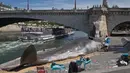 Sejumlah Warga melihat patung ikan paus berkuruan besar di sepanjang Sungai Seine di Paris, Prancis, (21/7). Kehadiran paus besar ini menjadi pusat perhatian turis dan warga Paris. (AP Photo / Michel Euler)