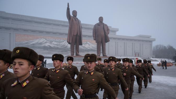 Tentara Korut usai memberi hormat untuk patung pemimpin Korea Utara Kim Il Sung dan Kim Jong Il selama Hari Peringatan Nasional di Bukit Mansu, Pyongyang (17/12).  Korea Utara tengah memperingati 7 tahun wafatnya  Kim Jong Il. (AFP Photo/Kim Won Jin)