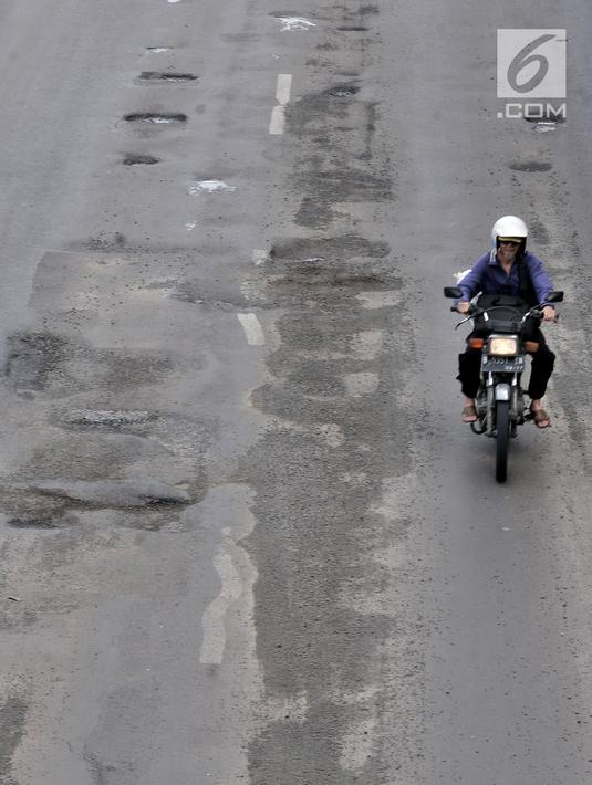 Pengendara motor menghindari jalan berlubang saat melintasi kawasan Gunung Sahari, Jakarta, Selasa (29/1).  Jalan rusak dan berlubang di sepanjang Jalan Gunung Sahari tersebut dapat membahayakan pengendara yang melintas. (Merdeka.com/Iqbal S. Nugroho)