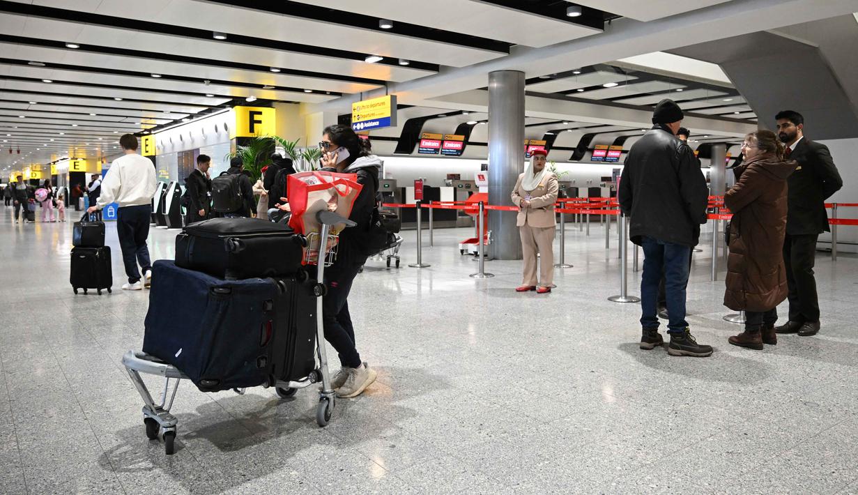Langkah ini sebagai tindakan pencegahan, untuk memastikan keselamatan penerbangan dan awak pesawat, penumpang, serta melindungi wilayah UEA. Tampak dalam foto, para penumpang berkumpul di area check-in Emirates yang ditutup di Bandara London Heathrow di London barat pada Minggu 1 Maret 2026, karena penerbangan sangat terganggu menyusul serangan Amerika Serikat dan Israel terhadap Iran. (JUSTIN TALLIS/AFP)